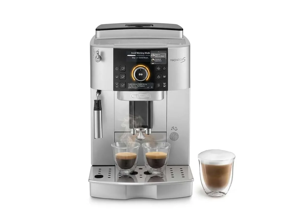 The DeLonghi Magnifica S automatic coffee machine, pulling two espressos beside a layered latte, with a concept &ldquo;Good Morning Mode&rdquo; screen shown above the grinder